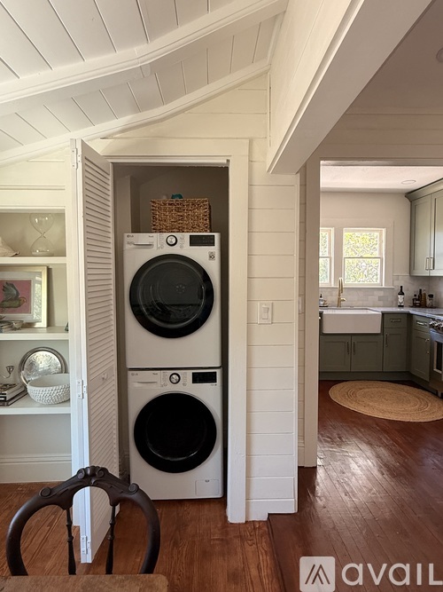 A washer and dryer are stacked on top of each other in a small laundry room.