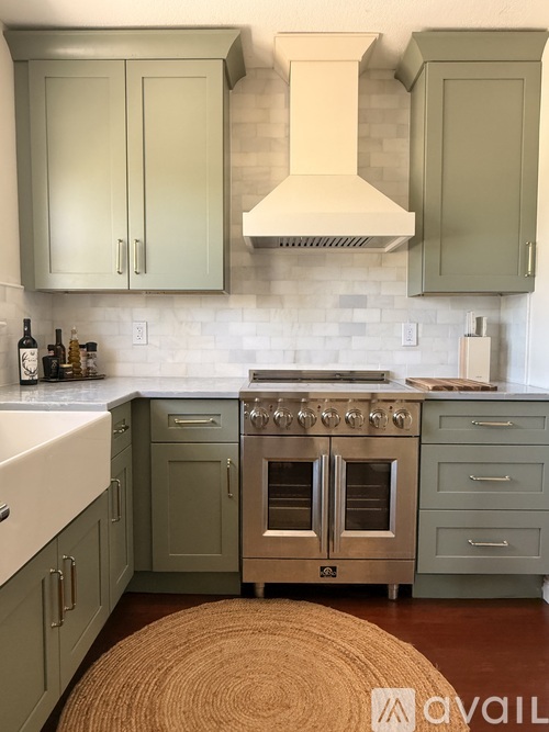 A kitchen with a stove top oven and a hood above it.