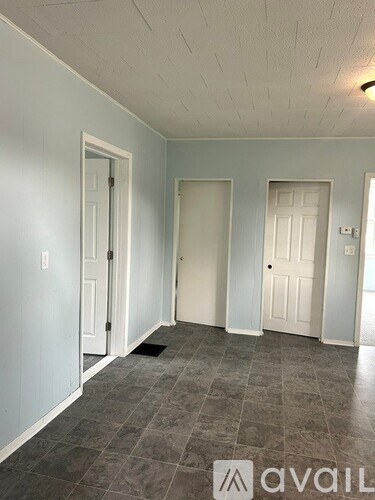 A room with three doors and a tiled floor.