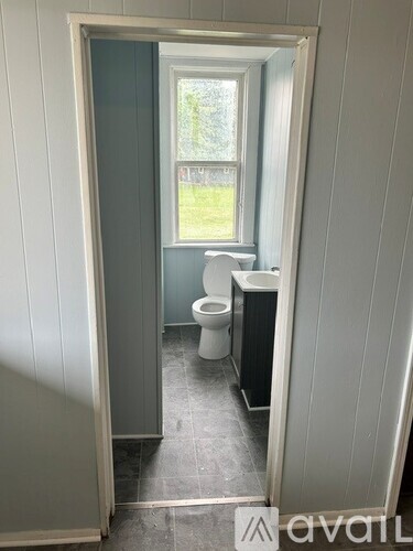 A bathroom with a toilet and a window.