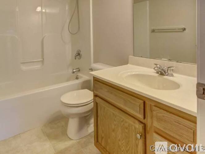 A white toilet sits next to a white sink in a bathroom.