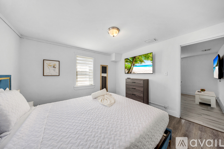 A bedroom with a large bed and a flat screen TV mounted on the wall.