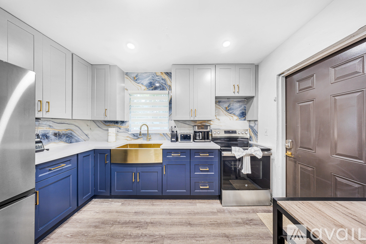 A kitchen with blue cabinets and a stainless steel refrigerator.