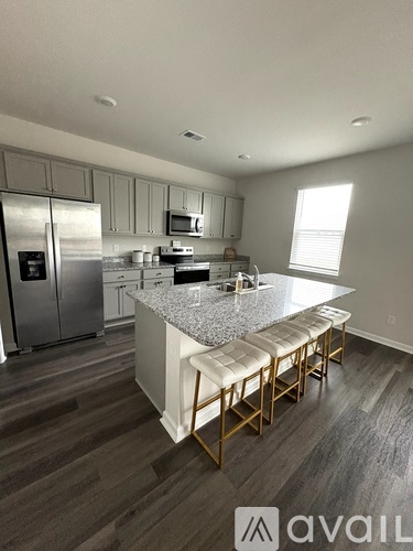 A kitchen with a granite countertop and stainless steel appliances.