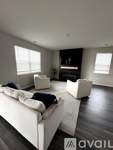 A living room with a white couch and a fireplace.