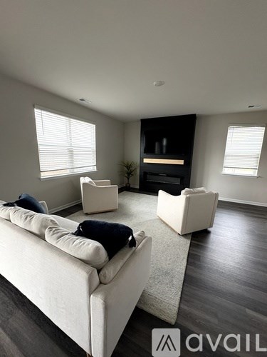 A living room with a white couch and a fireplace.