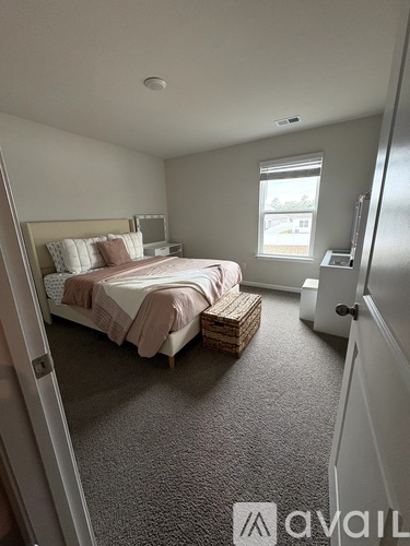 A bedroom with a bed and a window.