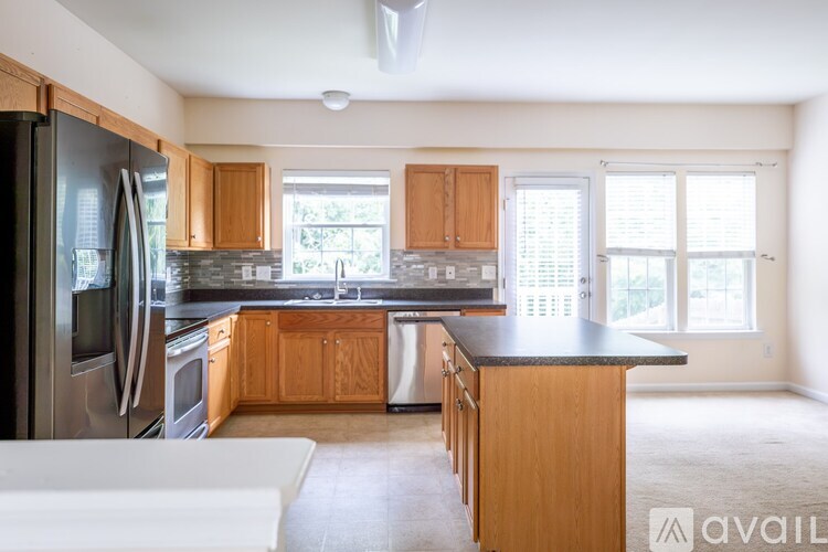 A kitchen with wooden cabinets and a black countertop.