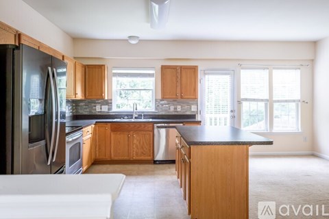 A kitchen with wooden cabinets and a black countertop.