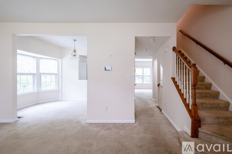 A spacious living room with a staircase leading to the upper floor.