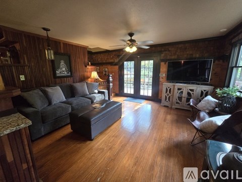 A living room with a dark grey couch and a wooden floor.