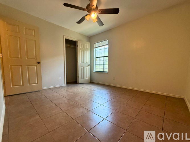 A room with a ceiling fan and tile flooring.