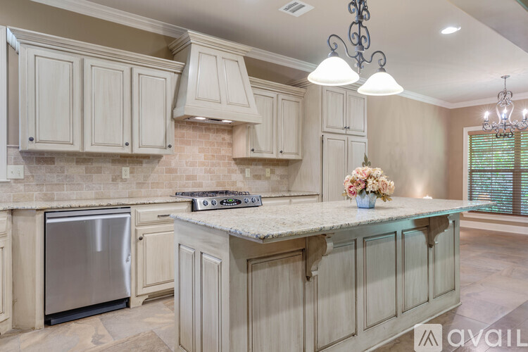 A kitchen with a stainless steel refrigerator and a marble countertop.