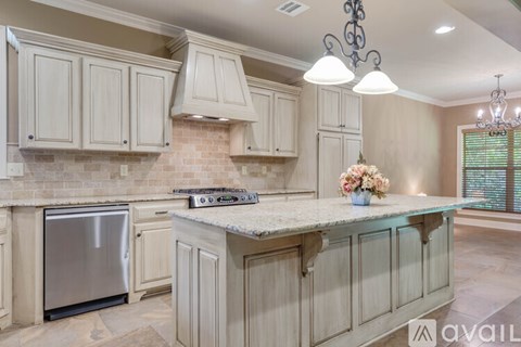 A kitchen with a stainless steel refrigerator and a marble countertop.