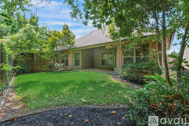 A house with a green lawn and trees around it.