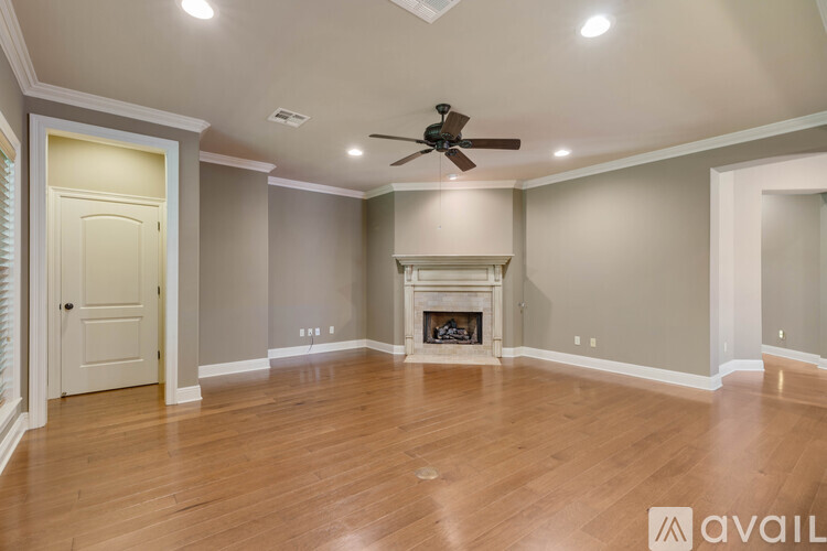 A spacious room with a fireplace and a ceiling fan.