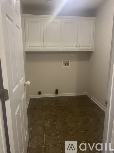 A kitchen with white cabinets and a tiled floor.