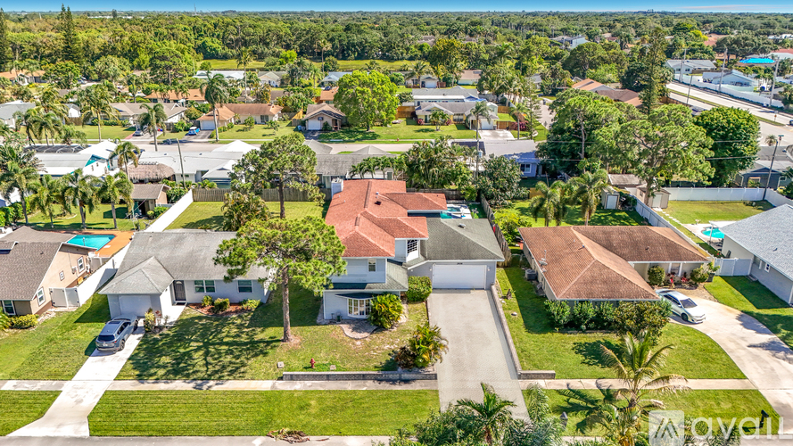 A bird's eye view of a residential neighborhood with houses and palm trees.