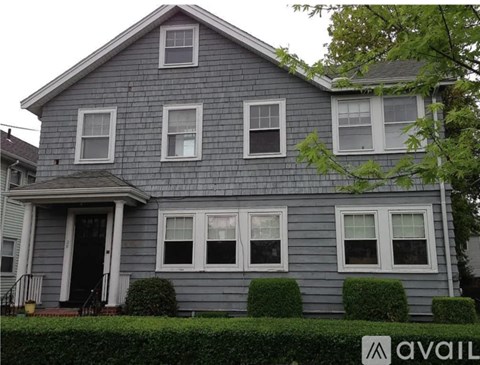 A house with a grey facade and white windows is for sale.