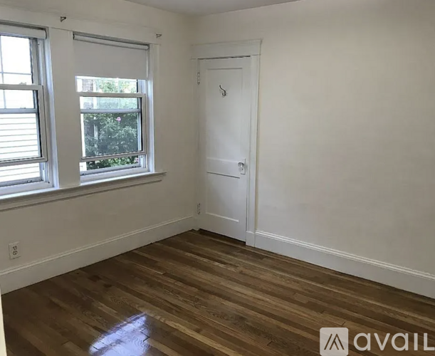 A room with a white door and a window with blinds.