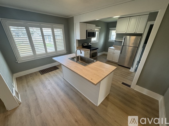 A kitchen with a wooden island in the middle of the room.