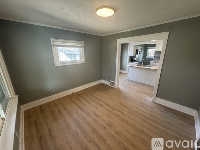 A room with wooden flooring and a window.