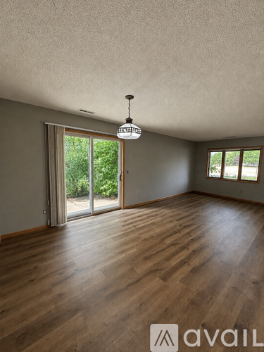 A room with wooden floors and a hanging light fixture.