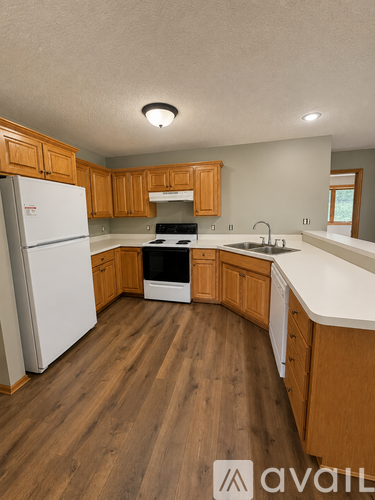 A kitchen with wooden cabinets and a white fridge.