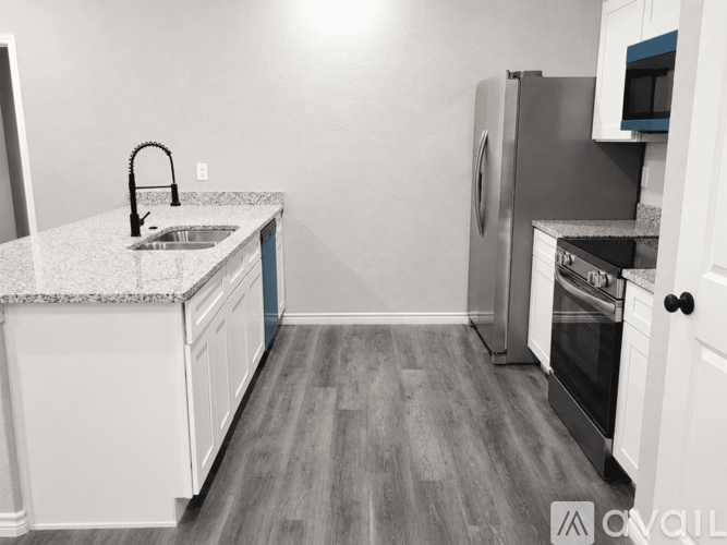 A kitchen with a sink, refrigerator, and oven.
