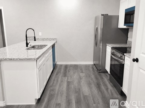 A kitchen with a sink, refrigerator, and oven.