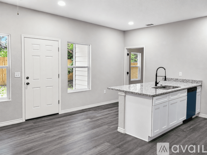 A kitchen with a granite countertop and white cabinets.