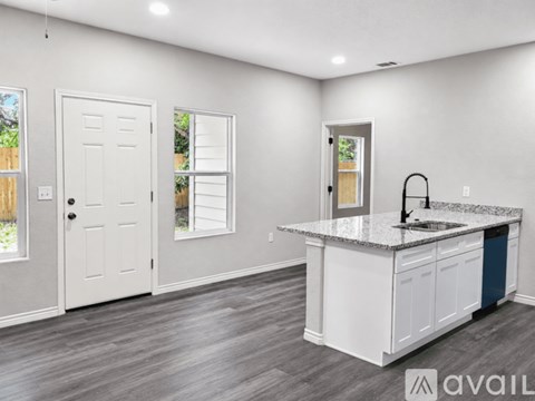 A kitchen with a granite countertop and white cabinets.