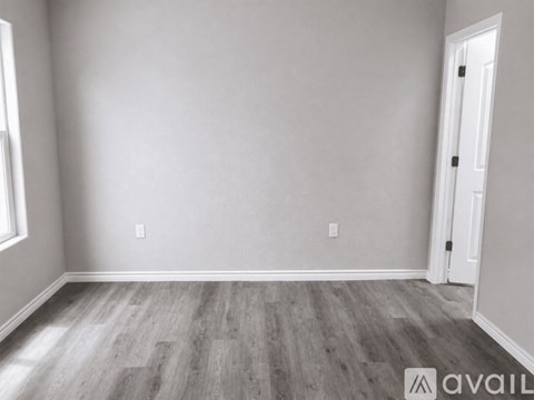 A room with wooden flooring and a white door.