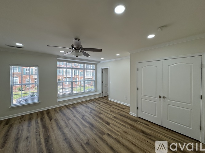 A spacious room with a ceiling fan and large windows.