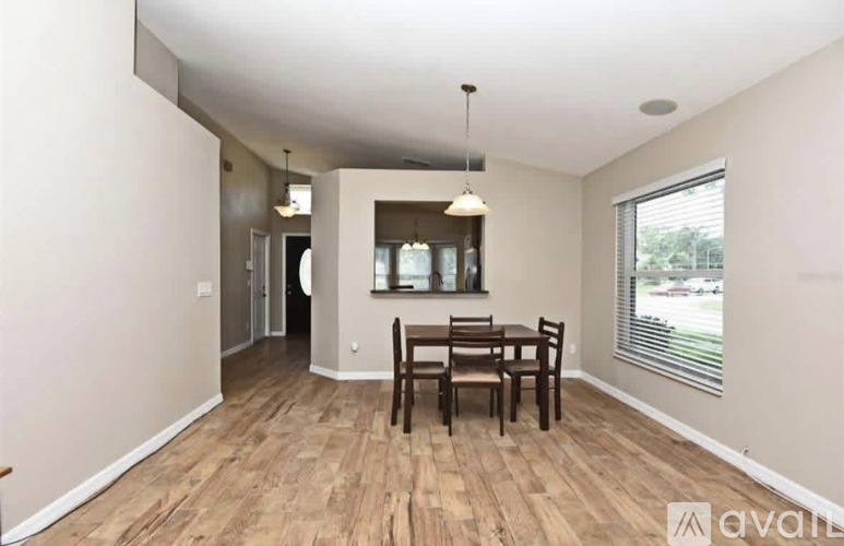 A dining room with a wooden table and chairs.