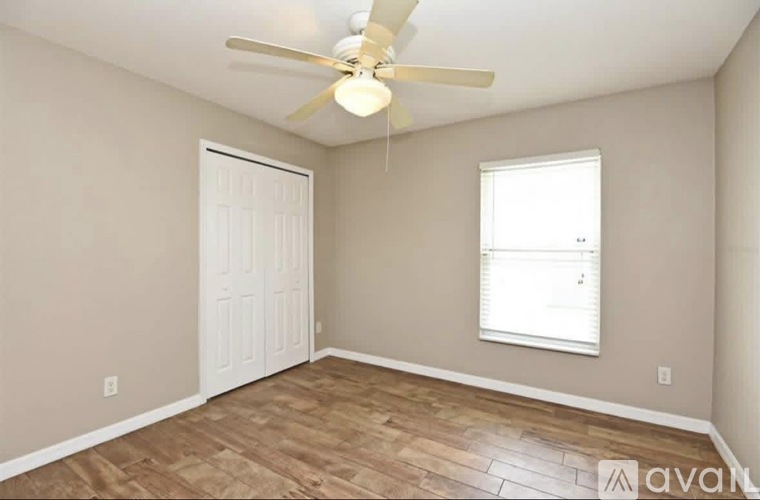 A room with a ceiling fan and a window.