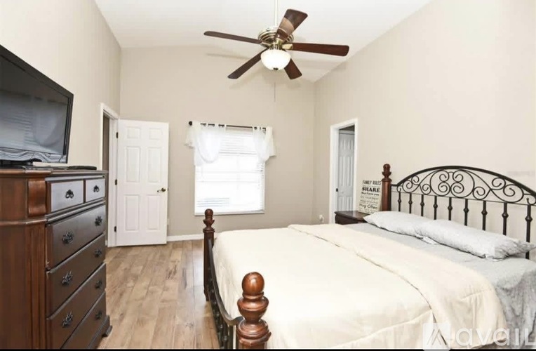A bedroom with a bed, dresser, and television.