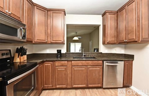 A kitchen with wooden cabinets and a black countertop.
