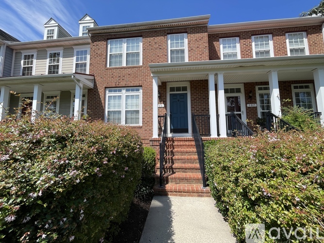 A row of red brick houses with white trim and windows.