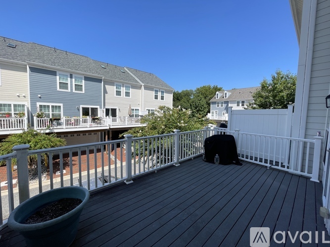 A man in a black suit is sitting on a wooden deck.