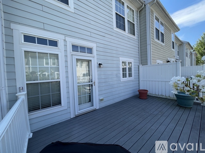A house with a grey siding and a white fence.