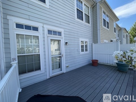 A house with a grey siding and a white fence.