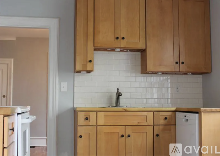 A kitchen with wooden cabinets and a white fridge.
