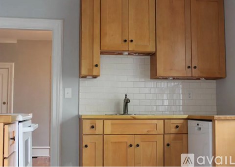 A kitchen with wooden cabinets and a white fridge.