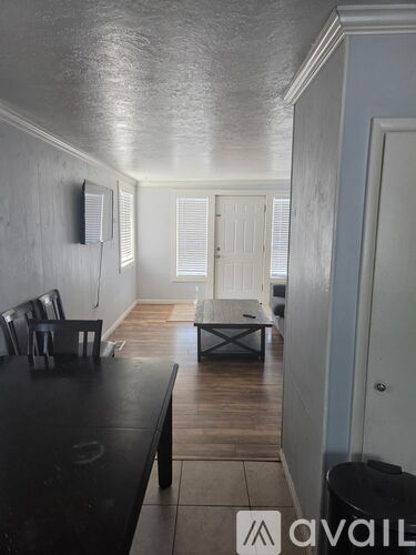 A dining room with a black table and chairs.
