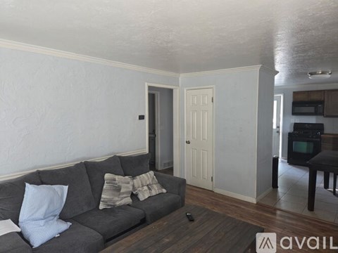 A living room with a grey couch and a remote control on it.