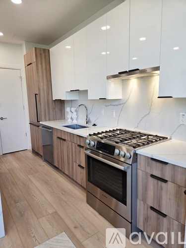 A kitchen with wooden cabinets and a stainless steel stove top.