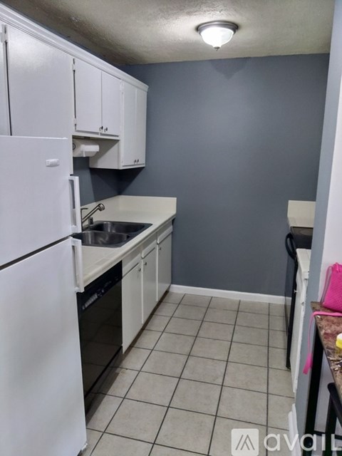 A kitchen with white appliances and cabinets.