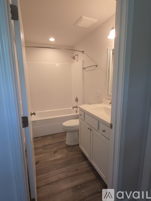A bathroom with a toilet, sink, and bathtub.