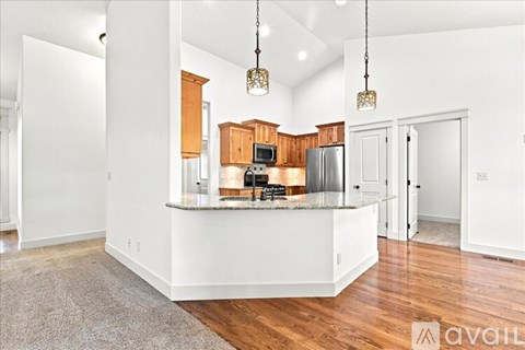 A kitchen with wooden cabinets and a granite countertop.
